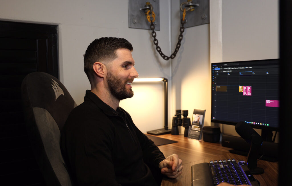Kane Tyler Smith smiling at his desk in the Smartfix office