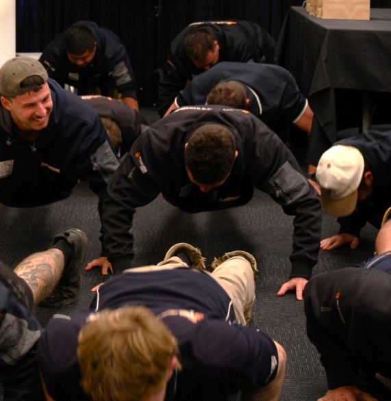 Smartfix tradies doing push-ups together in the office during Men's Mental Health Month
